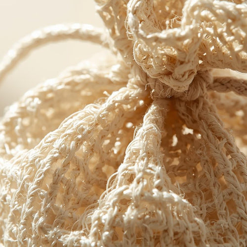Close-up of a textured beige decorative item with a string, on a soft focus background.